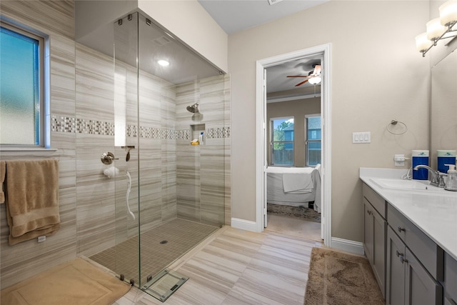 full bathroom with a shower stall, vanity, baseboards, and ceiling fan