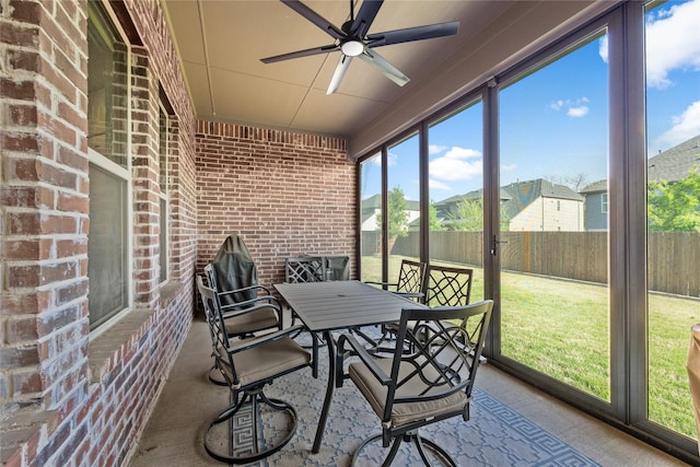 sunroom / solarium with outdoor dining space and ceiling fan