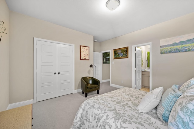 carpeted bedroom with ensuite bathroom, a closet, and baseboards
