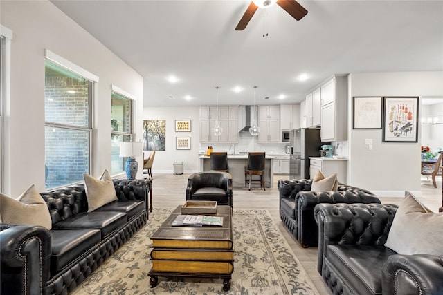 living area featuring light wood-style flooring, ceiling fan, recessed lighting, and baseboards