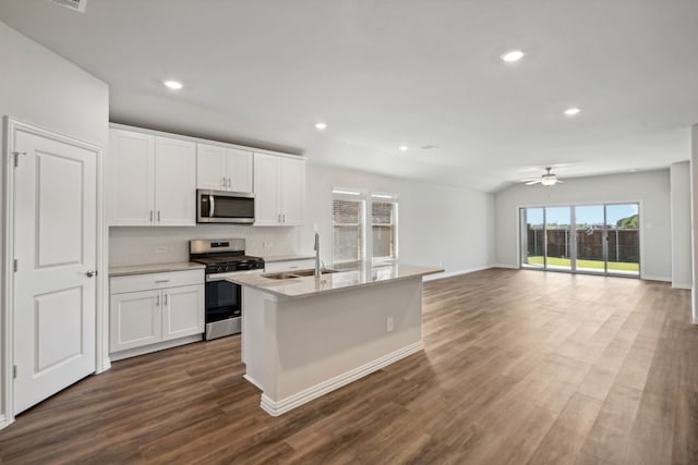 kitchen with a sink, dark wood-style floors, stainless steel appliances, white cabinets, and ceiling fan