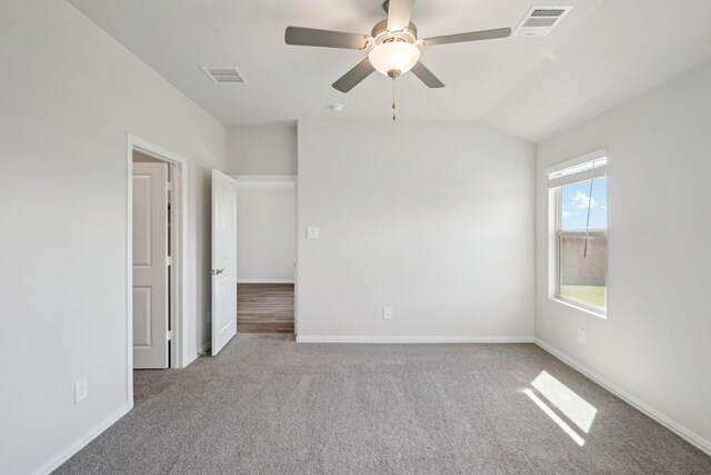 carpeted spare room with visible vents, baseboards, lofted ceiling, and ceiling fan