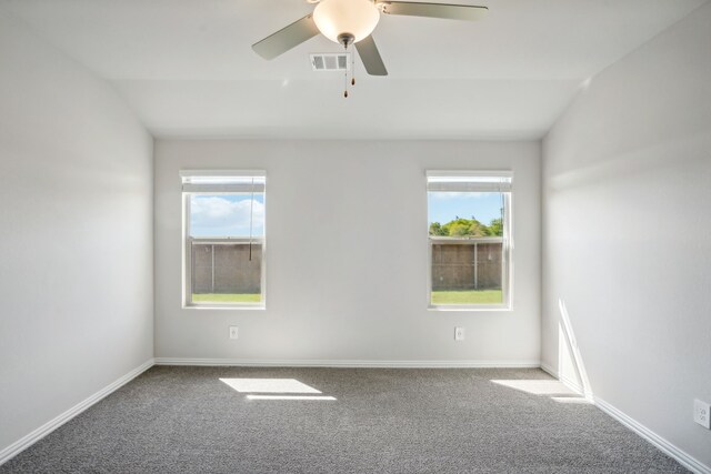 carpeted spare room with baseboards, visible vents, ceiling fan, and lofted ceiling