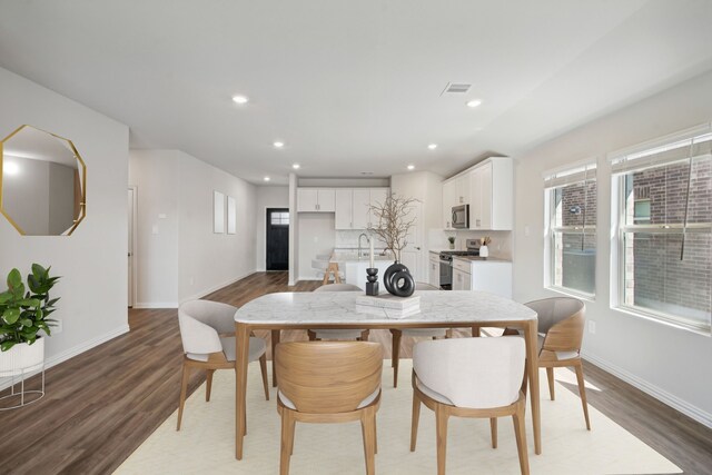 dining room featuring baseboards, visible vents, light wood-style flooring, and recessed lighting