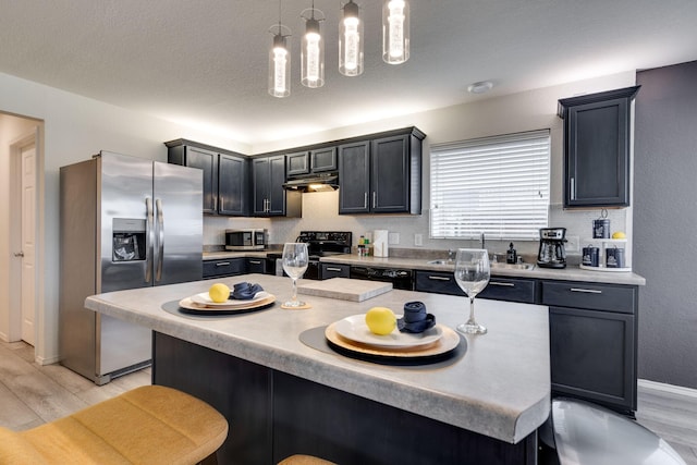 10617 Cochron Dr, Mckinney, TX 75072 - kitchen featuring a breakfast bar area, a sink, light countertops, black appliances, and light wood-style flooring