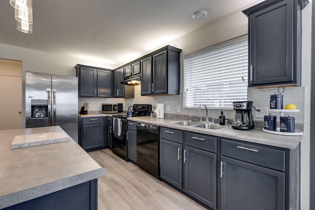 10617 Cochron Dr, Mckinney, TX 75072 - kitchen with a sink, light countertops, light wood-style flooring, backsplash, and black appliances