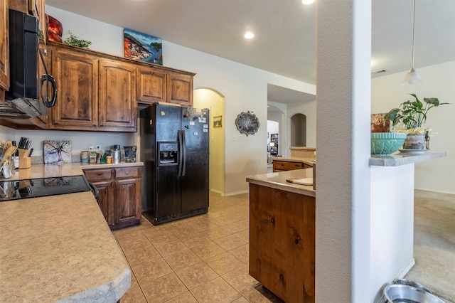 1129 Hidden Lake Dr, Burleson, TX 76028 - kitchen with light tile patterned floors, arched walkways, black appliances, light countertops, and baseboards