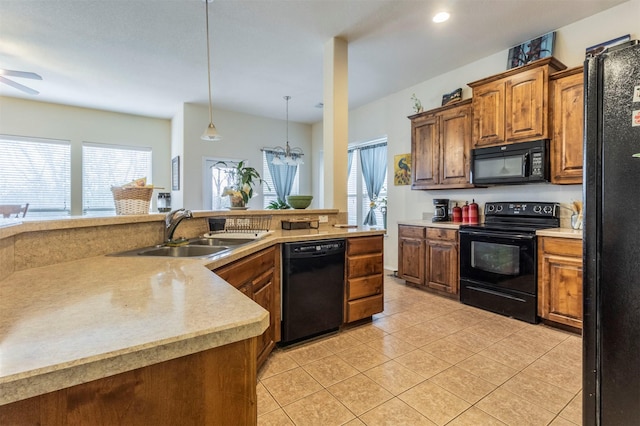 kitchen with ceiling fan with notable chandelier, light tile patterned floors, black appliances, light countertops, and a sink