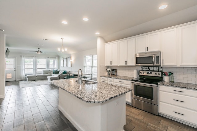 kitchen featuring a sink, wood tiled floor, decorative backsplash, stainless steel appliances, and white cabinets