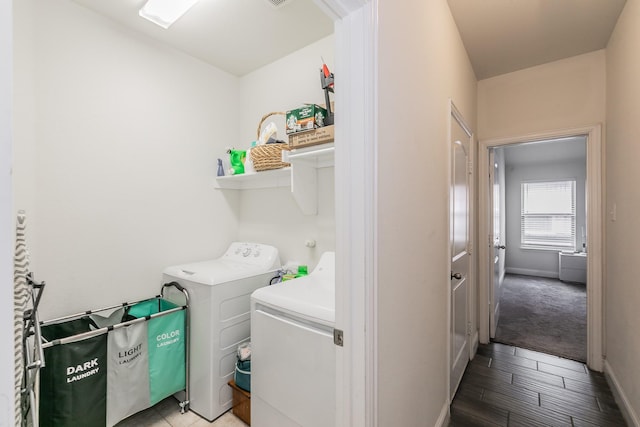 clothes washing area featuring light wood-style floors, washer and dryer, and laundry area