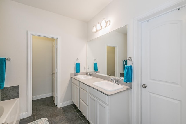 bathroom featuring double vanity, a bath, baseboards, and a sink