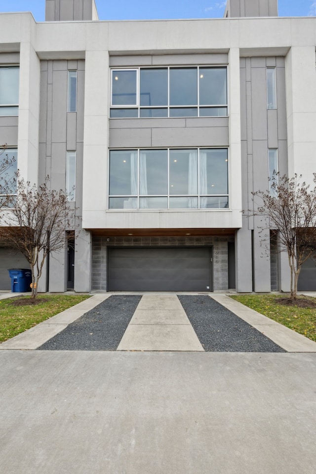 4980 Fuqua St, Dallas, TX 75206 - view of front of house featuring a garage, aphalt driveway, and stucco siding