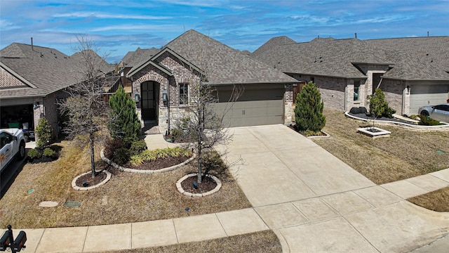 french provincial home featuring stone siding, brick siding, concrete driveway, and a garage