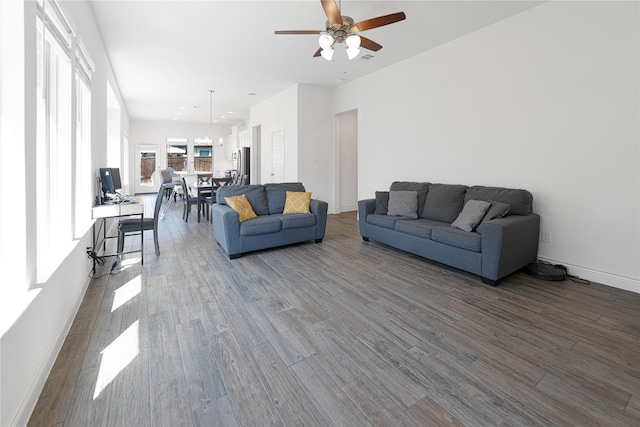 living area featuring a ceiling fan, dark wood-style floors, baseboards, and visible vents