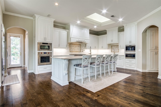 5816 Forest Highlands Dr, Fort Worth, TX 76132 - kitchen featuring arched walkways, visible vents, a breakfast bar area, and an island with sink