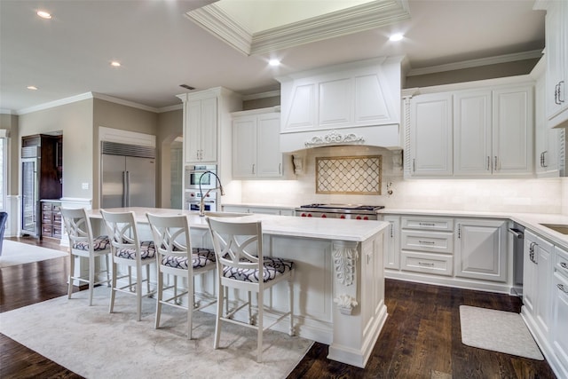 5816 Forest Highlands Dr, Fort Worth, TX 76132 - kitchen with custom exhaust hood, a kitchen island with sink, stainless steel appliances, white cabinetry, and dark wood-style floors