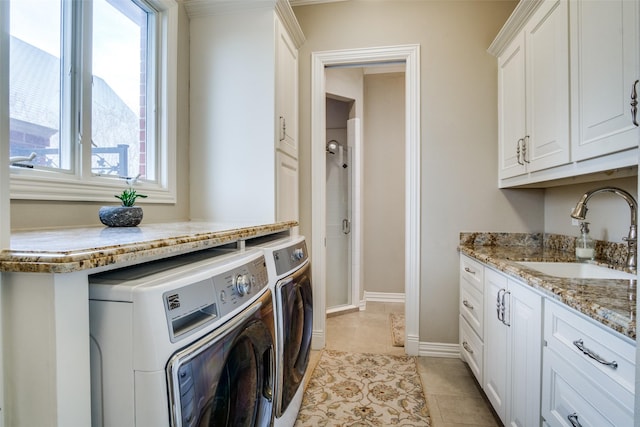 5816 Forest Highlands Dr, Fort Worth, TX 76132 - laundry area featuring light tile patterned flooring, baseboards, a sink, cabinet space, and washer and clothes dryer