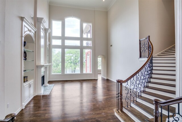 5816 Forest Highlands Dr, Fort Worth, TX 76132 - interior space featuring dark wood-style flooring, crown molding, stairs, a fireplace, and a towering ceiling
