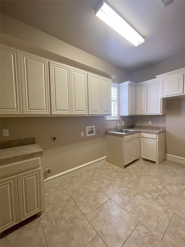 1304 Rollie Michael Ln, Fort Worth, TX 76179 - kitchen with baseboards, a sink, and white cabinetry
