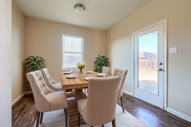 dining area with baseboards and wood finished floors