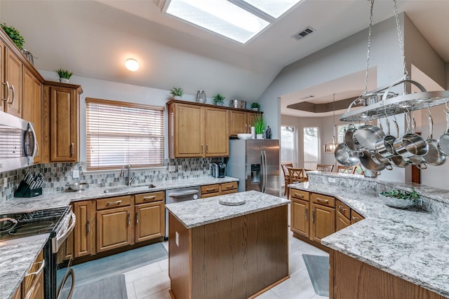 209 Timberbluff Ln, Murphy, TX 75094 - kitchen featuring visible vents, a kitchen island, brown cabinets, a sink, and appliances with stainless steel finishes