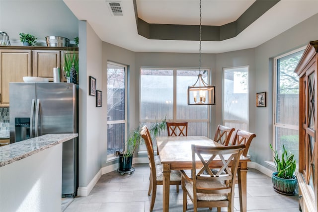 209 Timberbluff Ln, Murphy, TX 75094 - dining area with visible vents, baseboards, a tray ceiling, a chandelier, and light tile patterned floors
