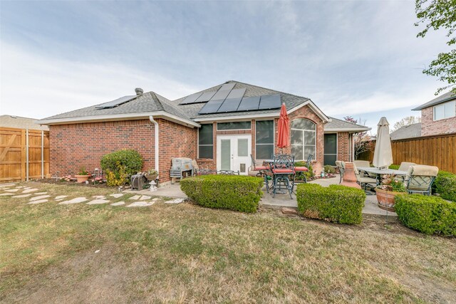 209 Timberbluff Ln, Murphy, TX 75094 - rear view of house with a yard, brick siding, solar panels, and a patio