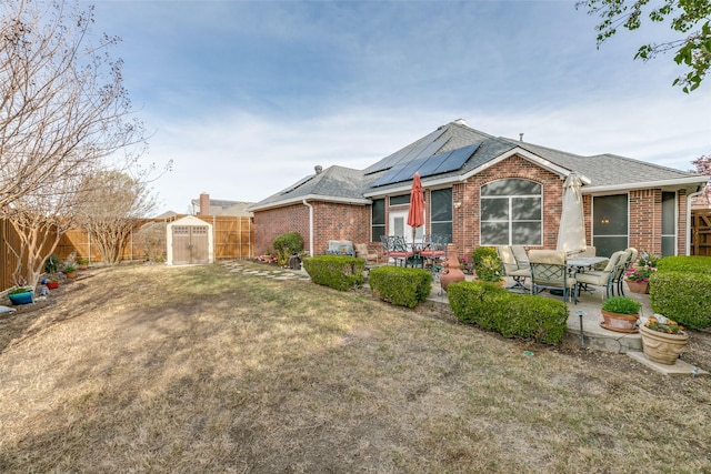 209 Timberbluff Ln, Murphy, TX 75094 - back of property with roof mounted solar panels, a fenced backyard, a patio area, and brick siding