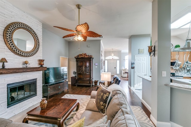 209 Timberbluff Ln, Murphy, TX 75094 - living area featuring ceiling fan, a stone fireplace, vaulted ceiling, wood finished floors, and baseboards