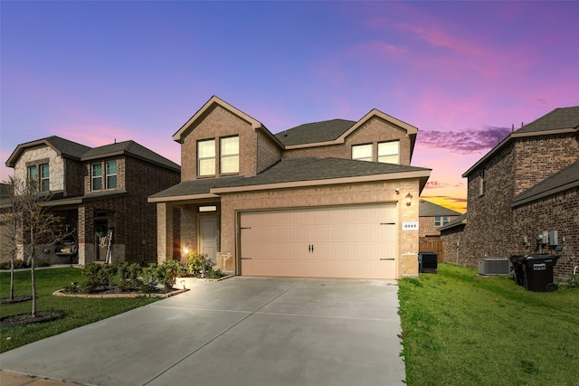 view of front of house featuring driveway, a yard, a garage, and roof with shingles