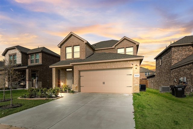 view of front of property featuring concrete driveway, a yard, a shingled roof, and an attached garage