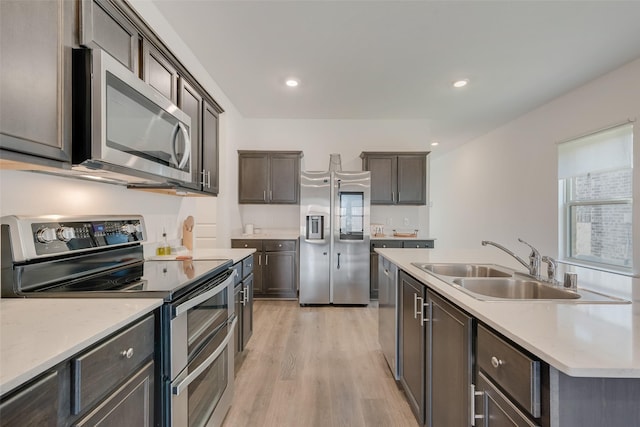 3213 Grimaldo Dr, Mesquite, TX 75126 - kitchen with appliances with stainless steel finishes, a sink, light wood finished floors, light countertops, and dark brown cabinets