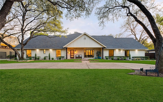 5230 Boca Raton Dr, Dallas, TX 75229 - modern inspired farmhouse featuring board and batten siding, a front lawn, curved driveway, and brick siding