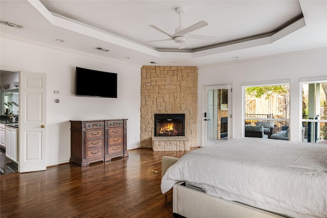 5230 Boca Raton Dr, Dallas, TX 75229 - bedroom featuring dark wood finished floors, a stone fireplace, a tray ceiling, and visible vents