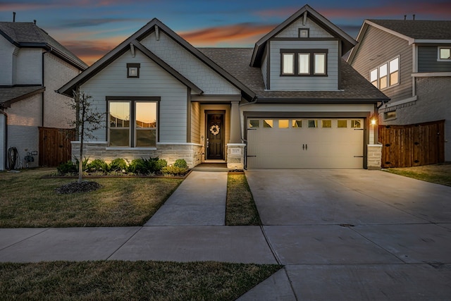 craftsman-style home featuring a front lawn, fence, stone siding, and driveway