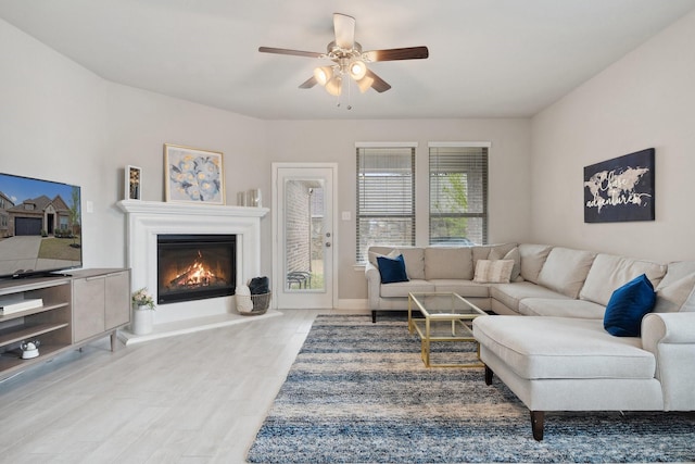 1702 Gallant Fox Dr, Rockwall, TX 75032 - living area with a glass covered fireplace, a ceiling fan, wood finished floors, and baseboards