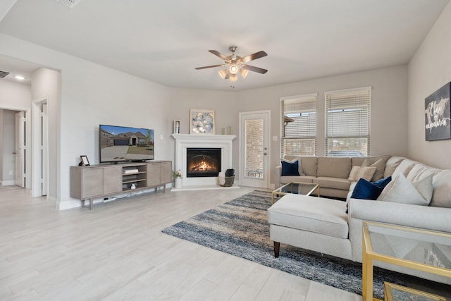 1702 Gallant Fox Dr, Rockwall, TX 75032 - living room featuring a ceiling fan, wood finished floors, a glass covered fireplace, and baseboards