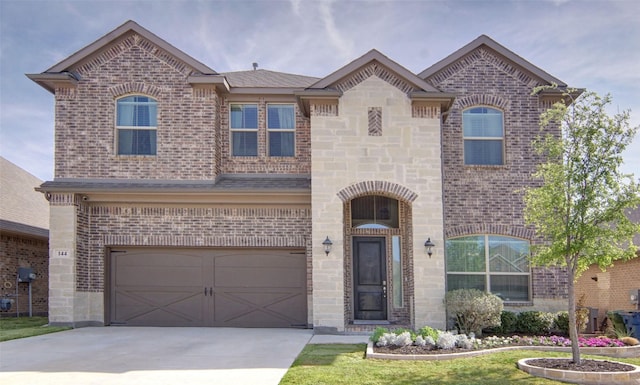 french country home featuring driveway, brick siding, a garage, and stone siding
