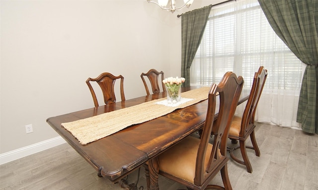 dining area with light wood finished floors, baseboards, and a chandelier