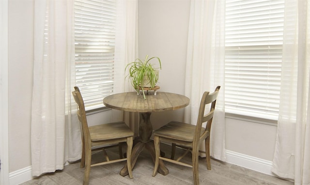 dining space featuring baseboards and wood finished floors