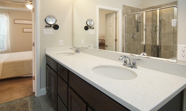 bathroom with double vanity, connected bathroom, a sink, and a shower stall