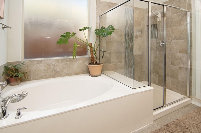 bathroom featuring a shower stall and a bath