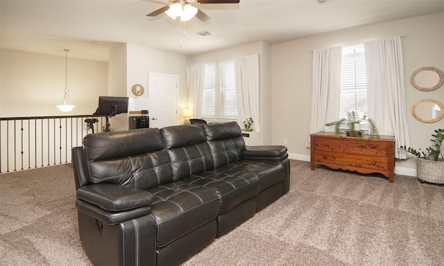 living room with carpet flooring, visible vents, baseboards, and ceiling fan