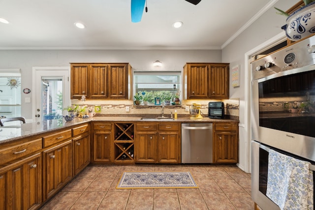 5835 Mapleshade Ln, Dallas, TX 75252 - kitchen featuring stainless steel appliances, brown cabinets, tasteful backsplash, ornamental molding, and a ceiling fan