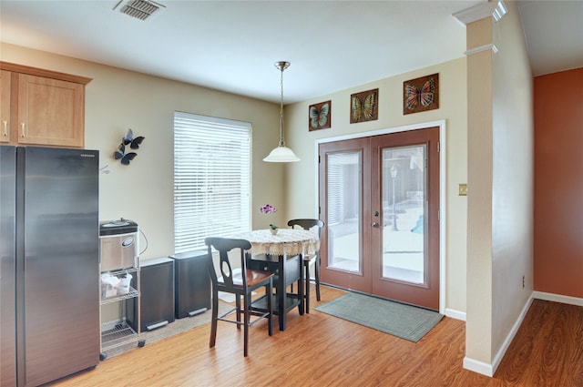 dining area featuring baseboards, visible vents, french doors, and light wood finished floors