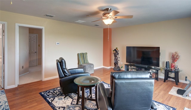 living room with baseboards, visible vents, a ceiling fan, and wood finished floors