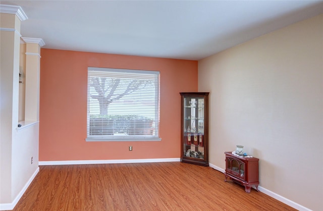 spare room with baseboards and light wood-style floors