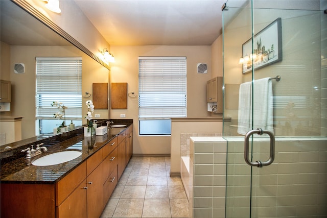 bathroom featuring double vanity, a bath, tile patterned flooring, and a sink