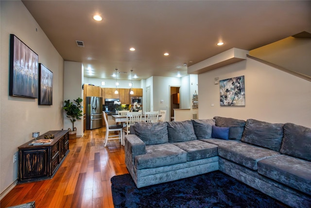 living area featuring visible vents, light wood finished floors, and recessed lighting