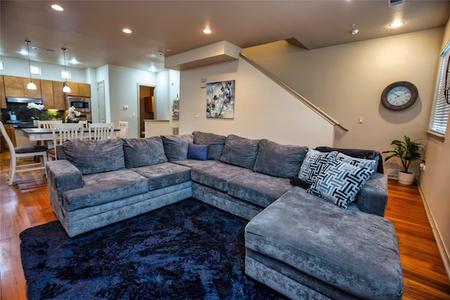 living area featuring baseboards, wood finished floors, and recessed lighting